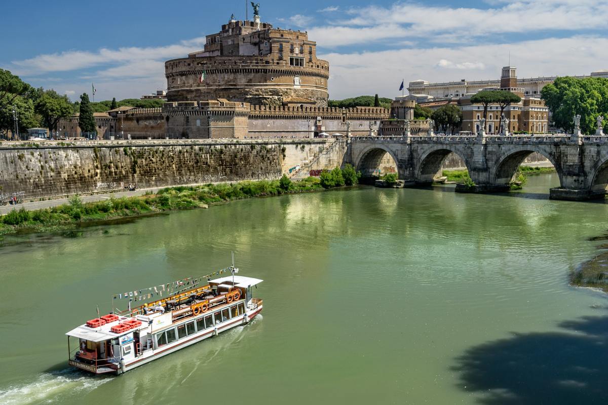 kent-rebman-5tm7a6DqIh0-unsplash a boat traveling across a bridge over a river