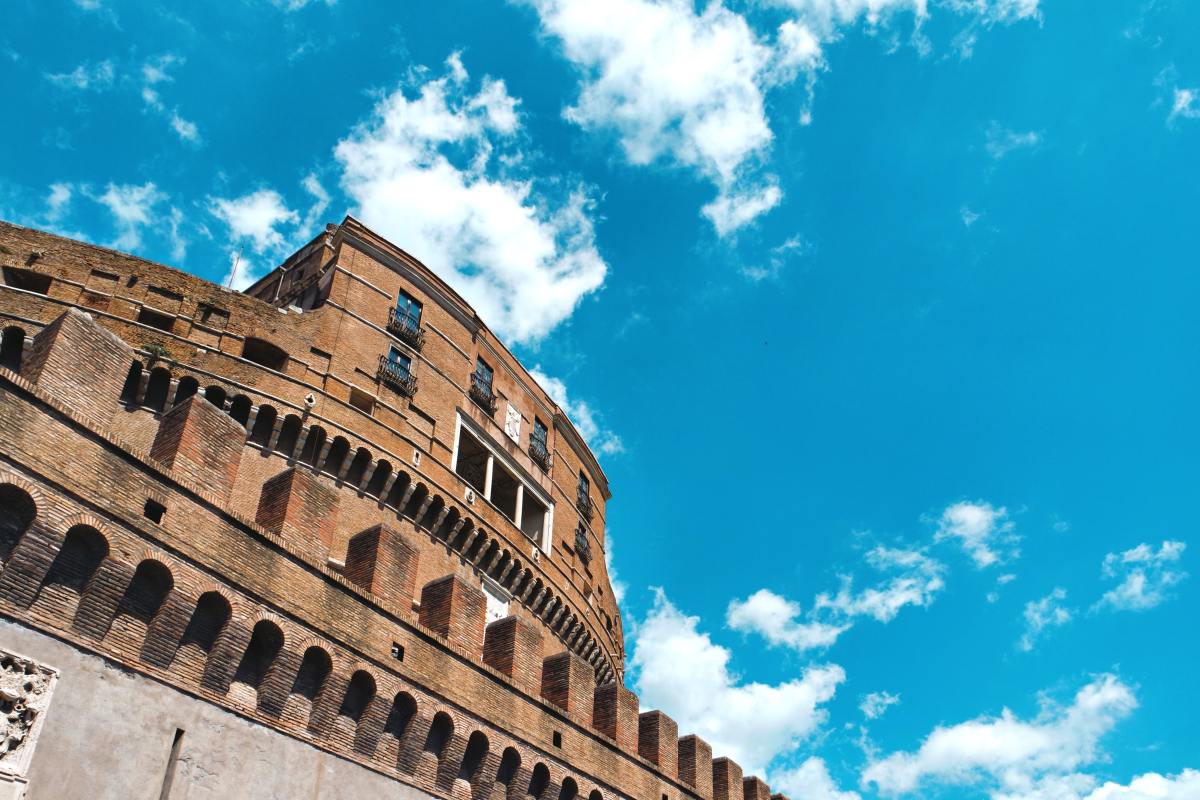 michele-bitetto-QBDHKCm7DRY-unsplash a large brick tower with a clock on the side of a building